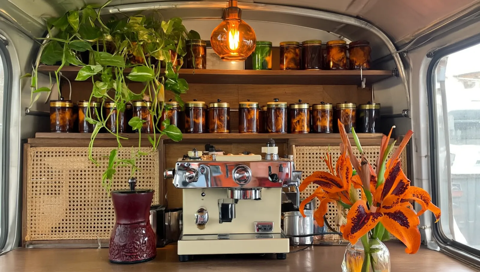 Concept of the trailer interior: walnut shelves, amber pendant lamp, rattan panels, espresso machine and tiger lilies